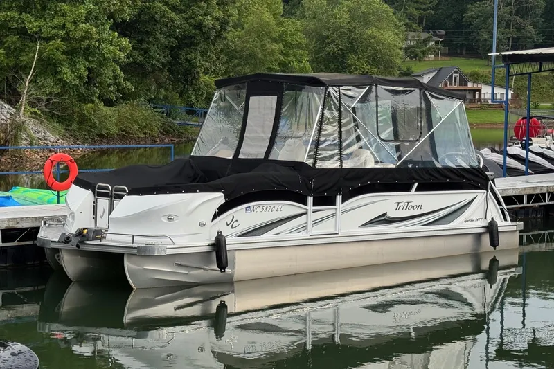 Slide: The Image of 2017 JC SportToon 24TT pontoon boat docked on a calm lake. - 1