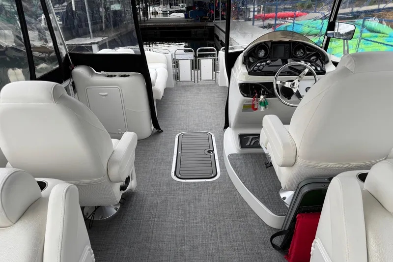 Slide: The Image of Interior of 2017 JC SportToon 24TT boat with white seating and modern dashboard. - 15