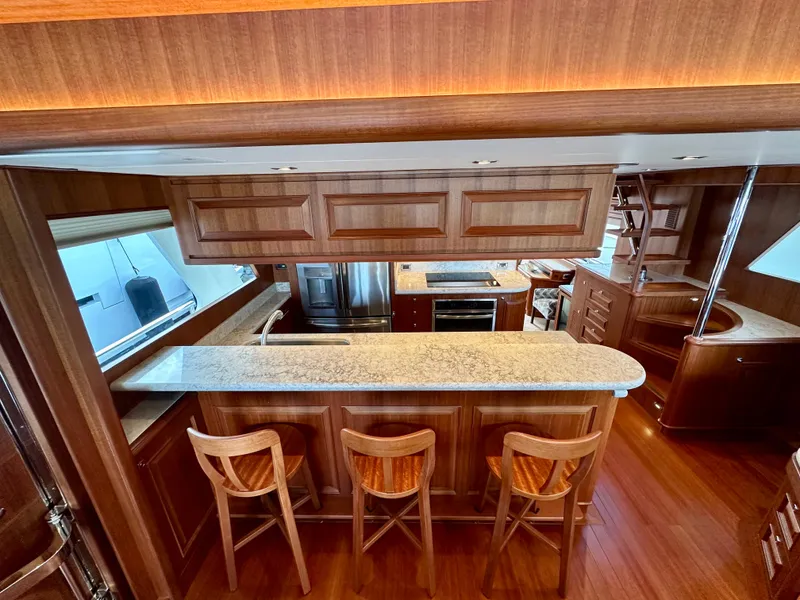 Slide: The Image of Luxurious 2020 Hampton 658l Endurance yacht kitchen with wooden cabinetry and bar seating. - 84
