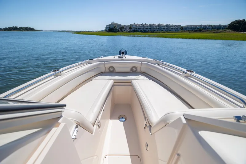 Slide: The Image of 2017 Grady-White Freedom 235 boat on calm water with scenic shoreline view. - 17