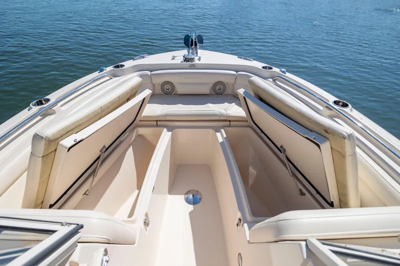 Slide: The Image of 2017 Grady-White Freedom 235 boat interior with open storage compartments on calm water. - 18