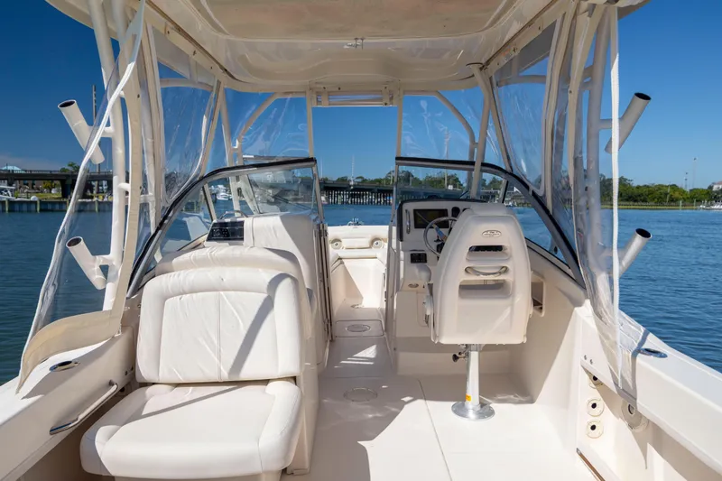 Slide: The Image of 2017 Grady-White Freedom 235 boat interior with seating and steering, docked on calm water. - 31