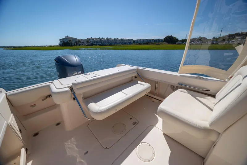 Slide: The Image of 2017 Grady-White Freedom 235 boat interior with seating, on a sunny day by the water. - 32