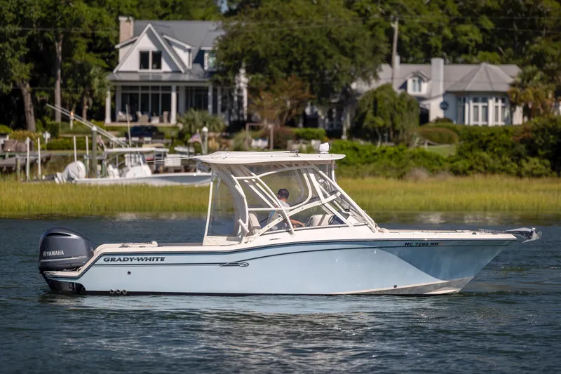 Slide: The Image of 2017 Grady-White Freedom 235 boat cruising on a scenic waterway near waterfront homes. - 5
