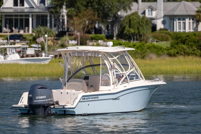 Slide: The Image of 2017 Grady-White Freedom 235 boat cruising on a scenic waterway near waterfront homes. - 6