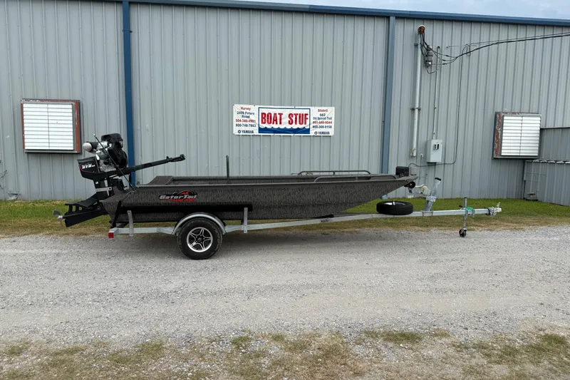 Slide: The Image of 2026 Gator Tail 1750 MID DECK SAVAGE boat on trailer outside metal building. - 1