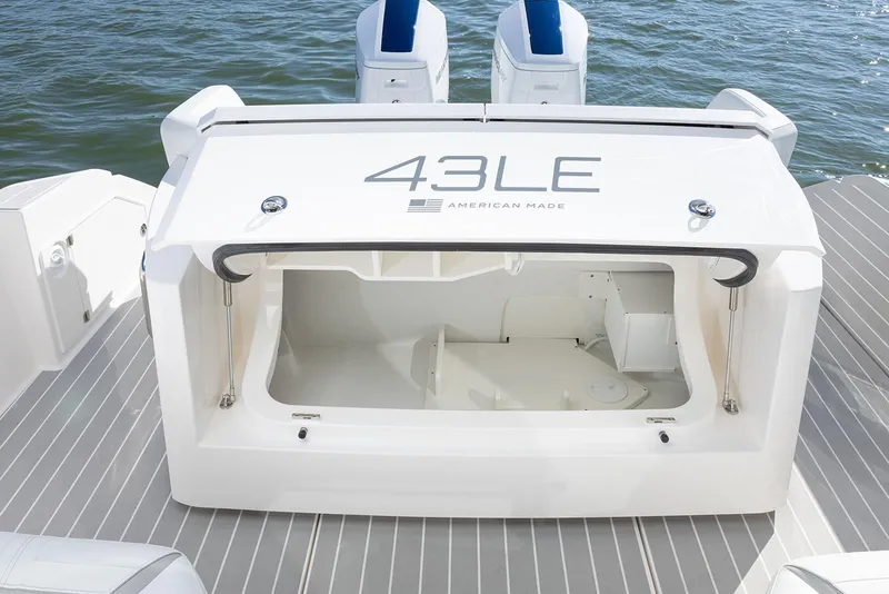 Slide: The Image of Manufacturer Provided Image: 2025 Tiara Yachts 43 LE boat storage compartment, open on deck, near water. - 11