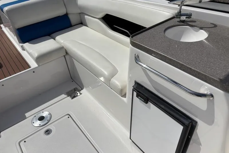 Slide: The Image of 2010 Regal 2700 ES Bowrider interior with white and blue seating and storage area. - 17