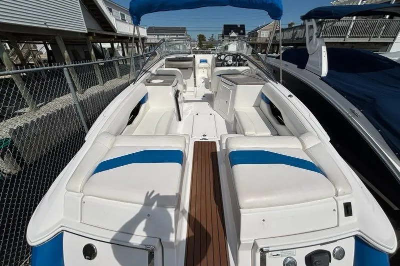 Slide: The Image of 2010 Regal 2700 ES Bowrider interior with white and blue seating, wooden deck. - 19