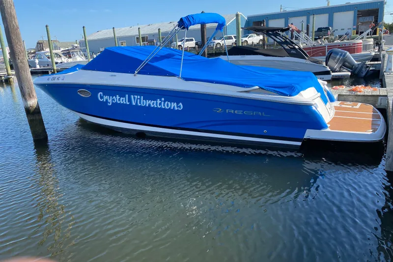 Slide: The Image of Blue 2010 Regal 2700 ES Bowrider boat named "Crystal Vibrations" docked at marina. - 22