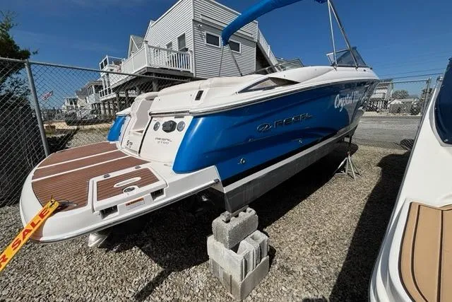 Slide: The Image of 2010 Regal 2700 ES Bowrider boat with blue cover, displayed for sale. - 4