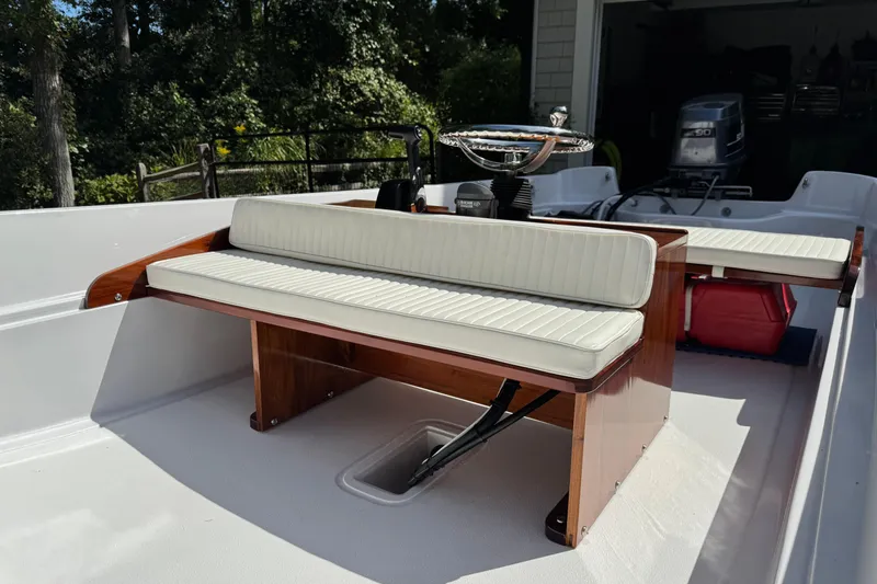 Slide: The Image of 1978 Boston Whaler Currituck boat interior with white cushioned seating and wooden accents. - 5