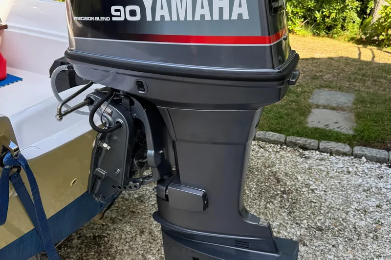 Slide: The Image of 1978 Boston Whaler Currituck with Yamaha 90 outboard motor, parked on gravel. - 6