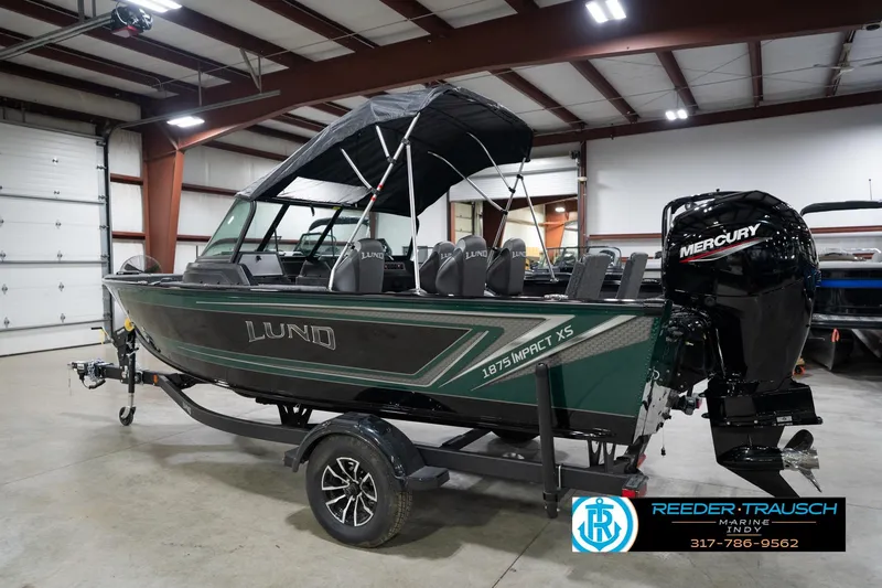 Slide: The Image of 2026 Lund 1875 Impact XS boat with Mercury engine in indoor showroom. - 10