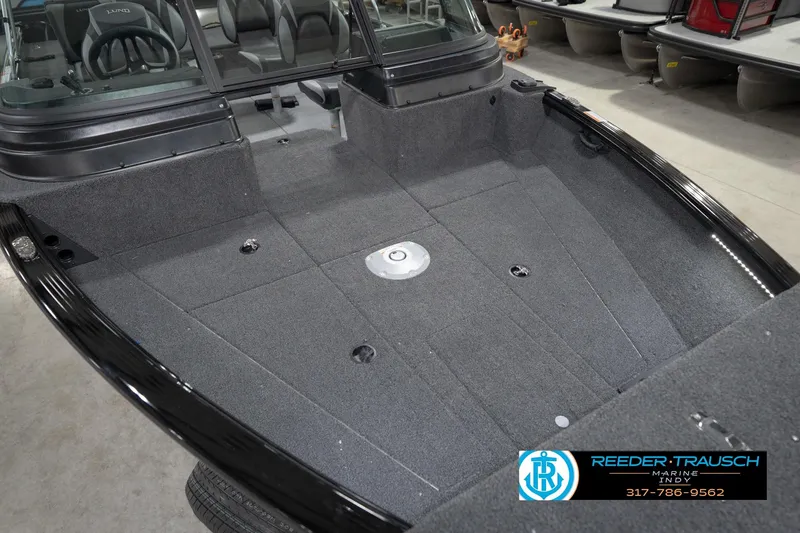 Slide: The Image of 2026 Lund 1875 Impact XS boat interior with gray carpeted deck and seating. - 13