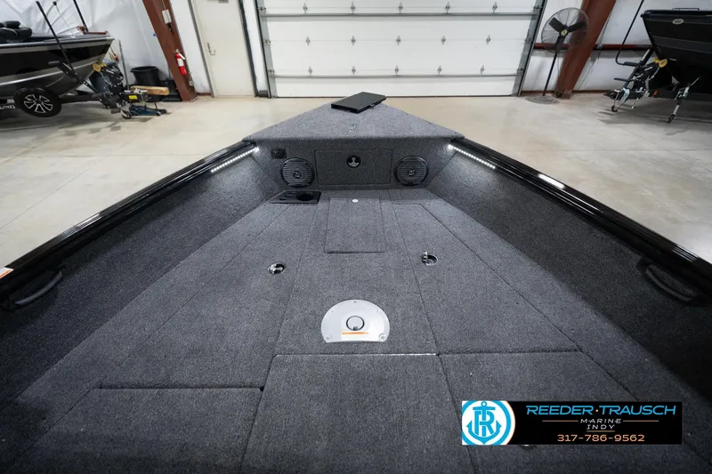 Slide: The Image of 2026 Lund 1875 Impact XS boat interior with carpeted deck and storage compartments. - 18