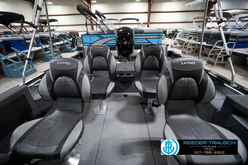 Slide: The Image of 2026 Lund 1875 Impact XS boat interior with four seats in a showroom. - 20