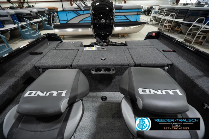 Slide: The Image of 2026 Lund 1875 Impact XS boat interior with seating and storage, displayed at Reeder-Trausch Marine. - 22