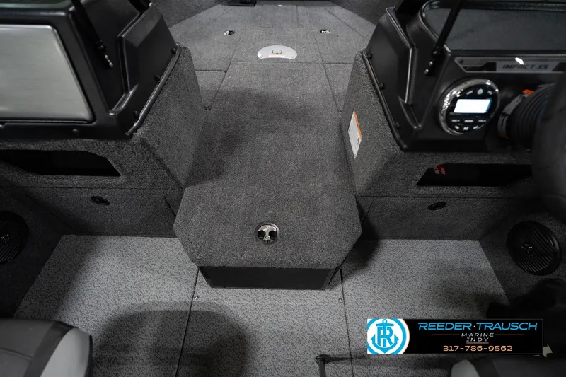 Slide: The Image of 2026 Lund 1875 Impact XS boat interior with carpeted flooring and control panel. - 25