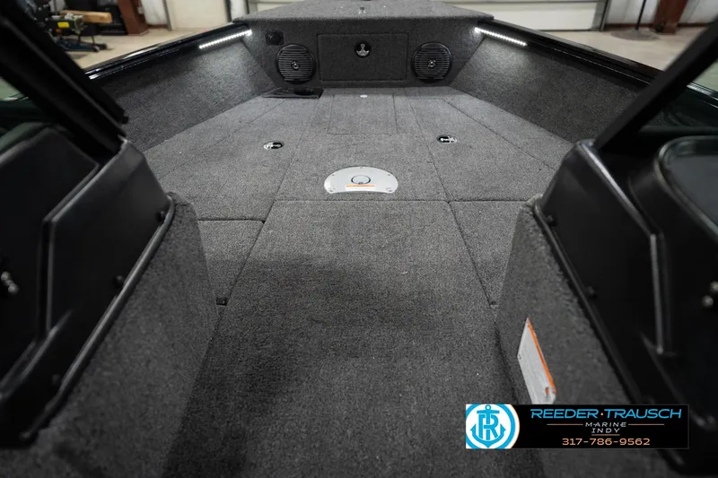 Slide: The Image of 2026 Lund 1875 Impact XS boat interior with carpeted deck and storage compartments. - 30