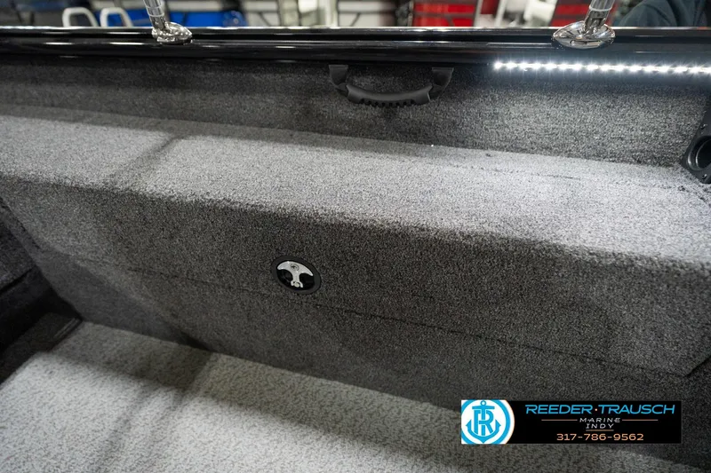 Slide: The Image of 2026 Lund 1875 Impact XS boat interior with carpeted storage compartment and LED lighting. - 32