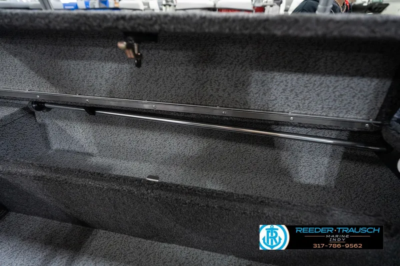 Slide: The Image of Interior storage compartment of 2026 Lund 1875 Impact XS boat, featuring carpeted finish. - 33