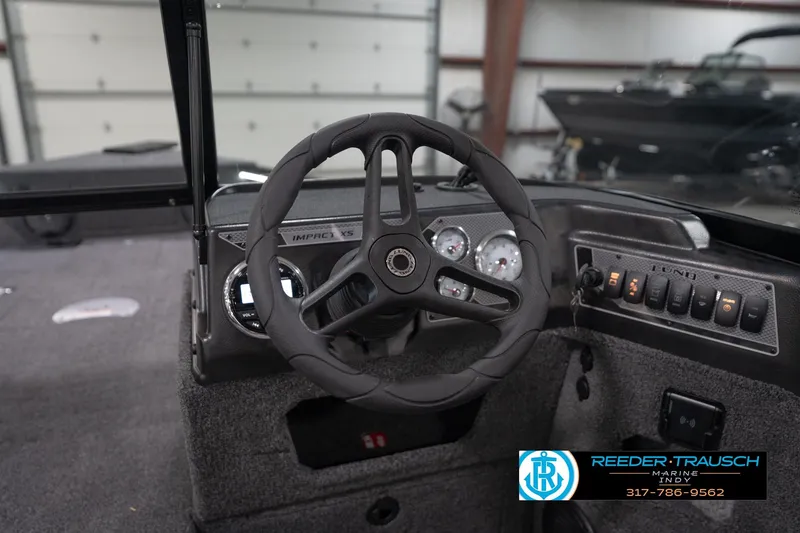 Slide: The Image of 2026 Lund 1875 Impact XS boat dashboard with steering wheel and control panel. - 35