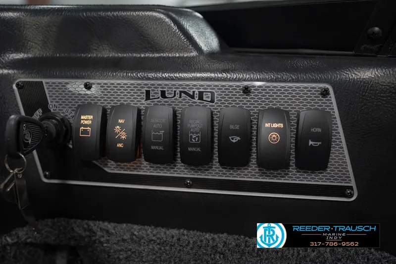 Slide: The Image of Control panel of 2026 Lund 1875 Impact XS boat with labeled switches and key ignition. - 39