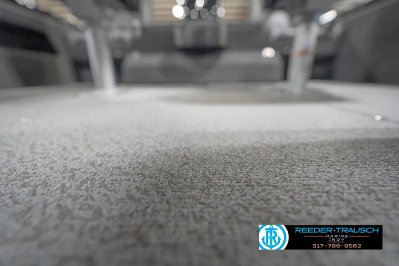 Slide: The Image of Carpeted interior of 2026 Lund 1875 Impact XS boat, featuring Reeder-Trausch Marine logo. - 49