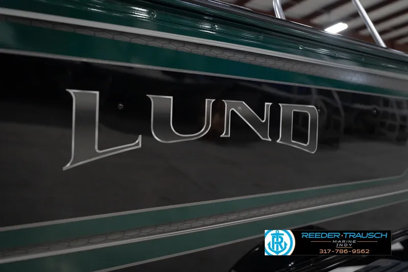 Slide: The Image of 2026 Lund 1875 Impact XS boat side view with logo and dealership contact. - 55