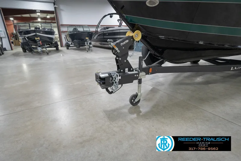 Slide: The Image of 2026 Lund 1875 Impact XS boat on trailer in showroom, Reeder Trausch Marine logo visible. - 58