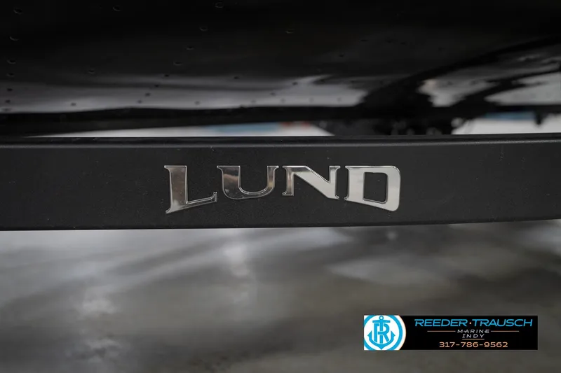 Slide: The Image of 2026 Lund 1875 Impact XS boat logo on black surface, Reeder Trausch Marine contact details. - 59