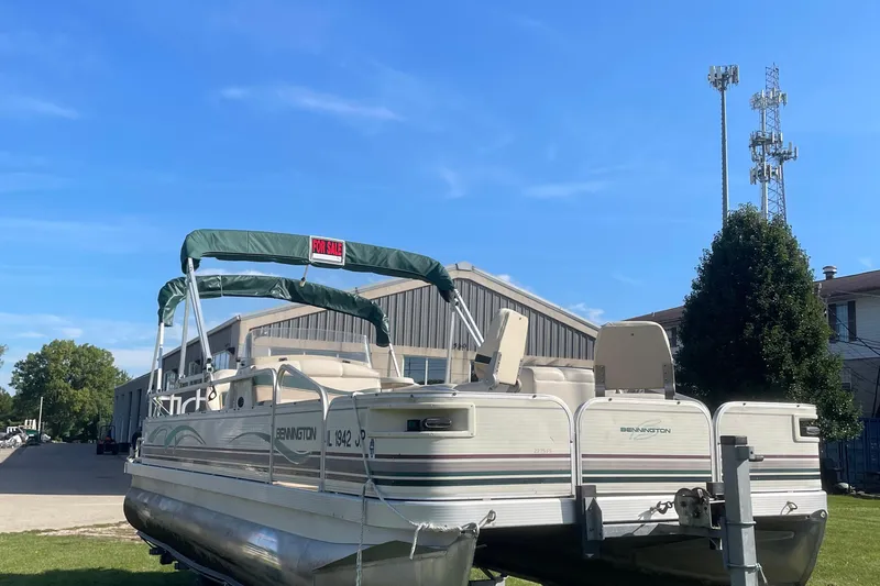 Slide: The Image of 2000 Bennington 2275FS pontoon boat for sale, parked outdoors under clear blue sky. - 3