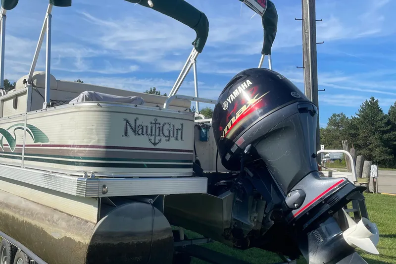 Slide: The Image of 2000 Bennington 2275FS pontoon boat with Yamaha outboard motor, labeled "NautiGirl," on grassy area. - 4