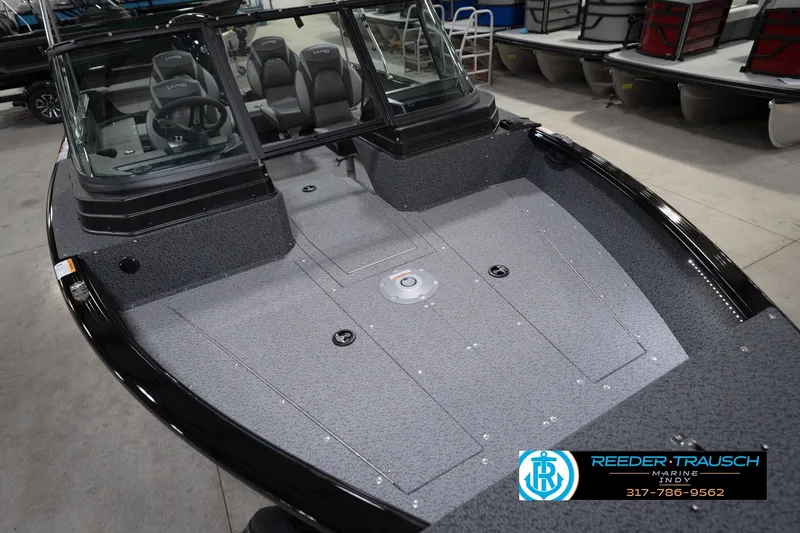 Slide: The Image of 2026 Lund 1800 Explorer Sport boat interior with seating and windshield in showroom. - 13