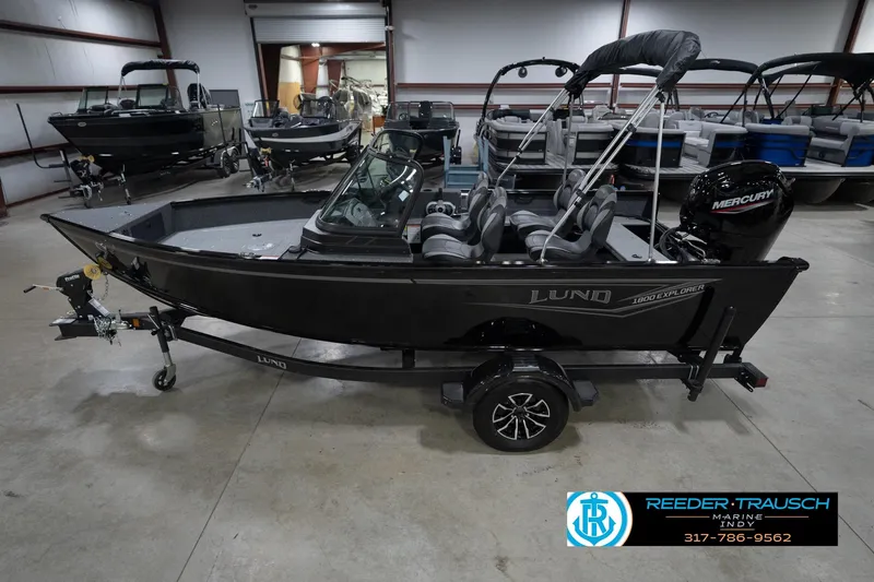 Slide: The Image of 2026 Lund 1800 Explorer Sport boat in showroom, black exterior, on trailer. - 2