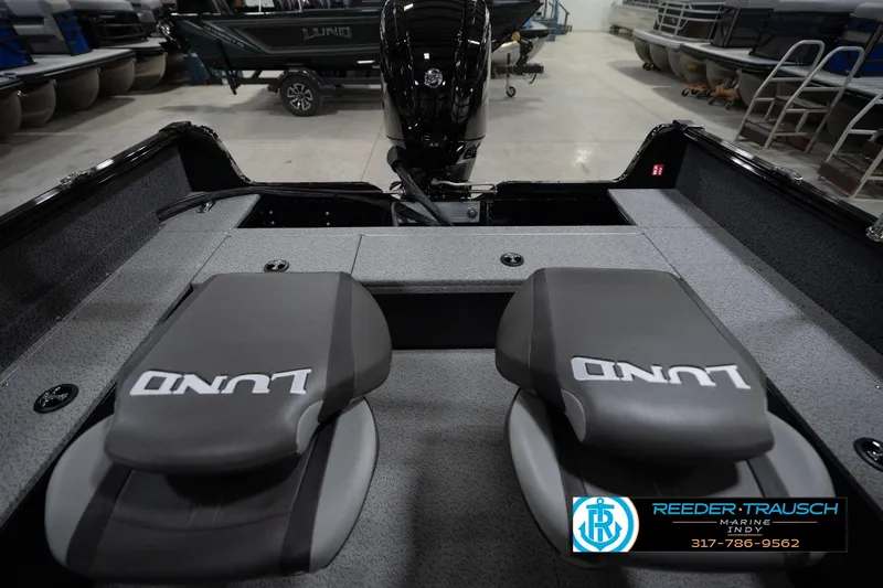Slide: The Image of 2026 Lund 1800 Explorer Sport boat interior in showroom, featuring spacious seating and modern design. - 22
