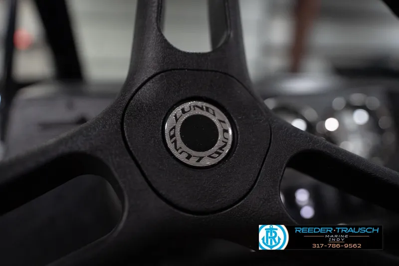 Slide: The Image of 2026 Lund 1800 Explorer Sport boat interior with gray textured flooring and console details. - 33