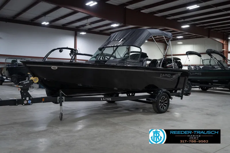 Slide: The Image of 2026 Lund 1800 Explorer Sport boat in showroom, front view, on trailer. - 4