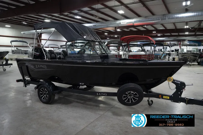 Slide: The Image of 2026 Lund 1800 Explorer Sport boat in showroom, featuring Mercury engine and trailer. - 6