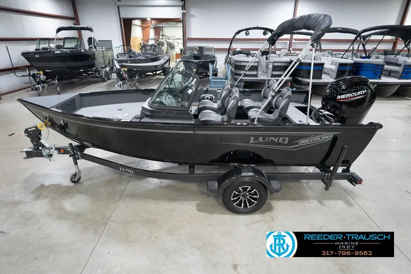 The Image of 2026 Lund 1800 Explorer Sport boat in showroom, featuring sleek design and Mercury engine. - 60