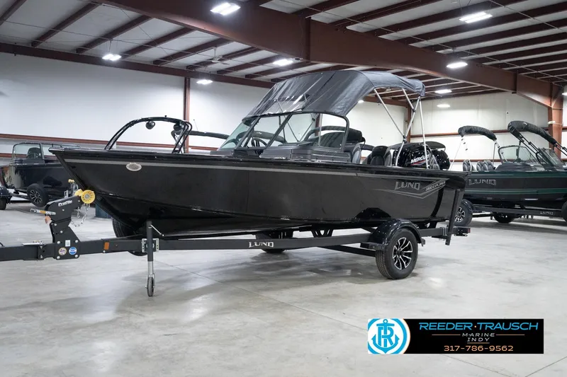 Slide: The Image of 2026 Lund 1800 Explorer Sport boat in showroom, black exterior, on trailer. - 62