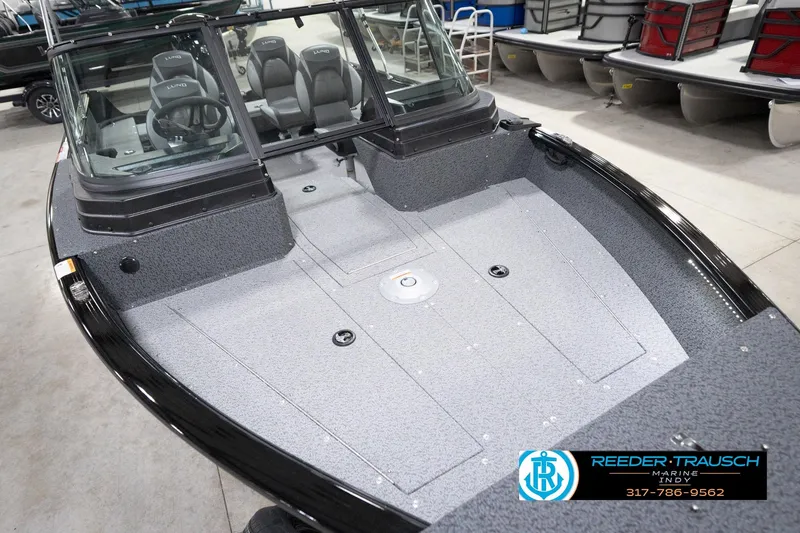 Slide: The Image of 2026 Lund 1800 Explorer Sport boat interior with seating and steering wheel, displayed indoors. - 71