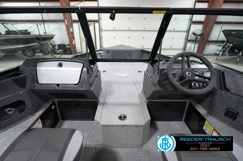 Slide: The Image of 2026 Lund 1800 Explorer Sport boat interior with steering wheel and dashboard in showroom. - 75