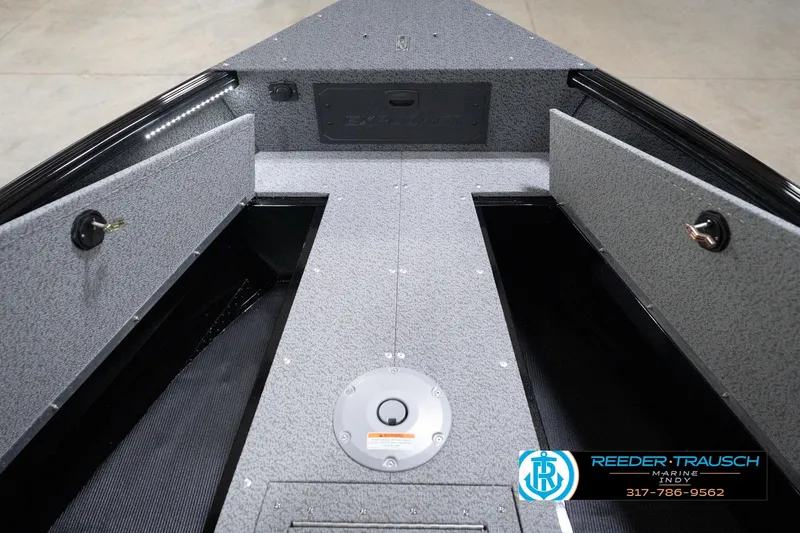 Slide: The Image of 2026 Lund 1800 Explorer Sport boat interior with storage compartments and Reeder-Trausch Marine logo. - 88
