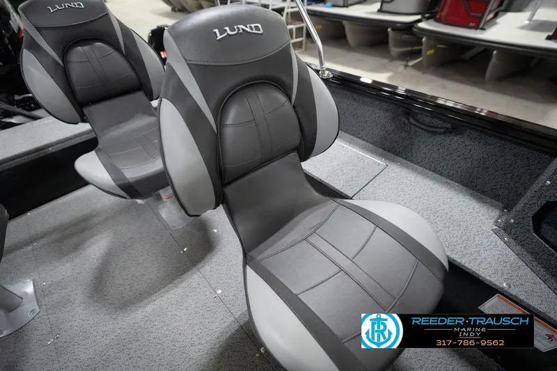 Slide: The Image of 2026 Lund 1800 Explorer Sport boat seats, gray and black design, in showroom setting. - 99