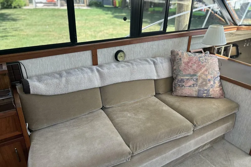 Slide: The Image of 1985 Carver 3207 Aft Cabin interior with beige sofa, patterned pillow, and lamp. - 19