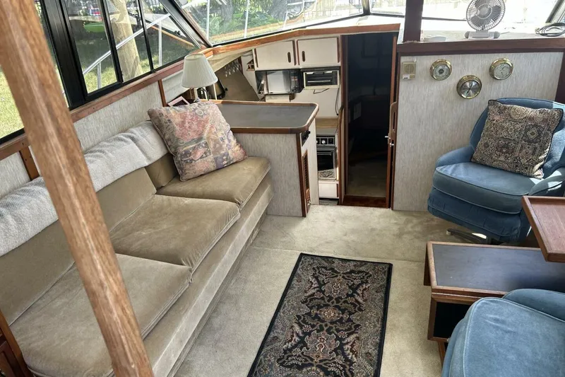 Slide: The Image of 1985 Carver 3207 Aft Cabin interior with cozy seating, carpet, and nautical decor. - 20