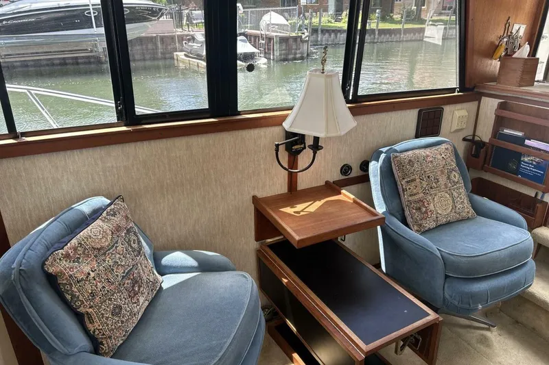 Slide: The Image of Interior of 1985 Carver 3207 Aft Cabin with blue chairs and decorative pillows. - 21