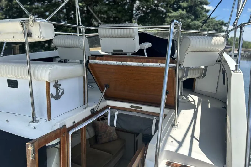 Slide: The Image of 1985 Carver 3207 Aft Cabin boat interior with white seating and wooden accents. - 22